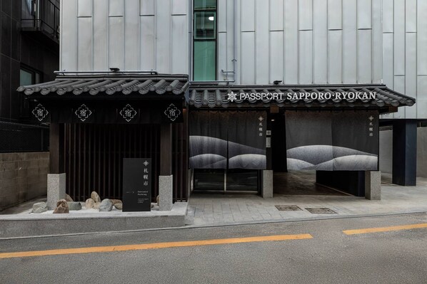 Un edificio con una entrada de baldosas tradicionales y fachada moderna.