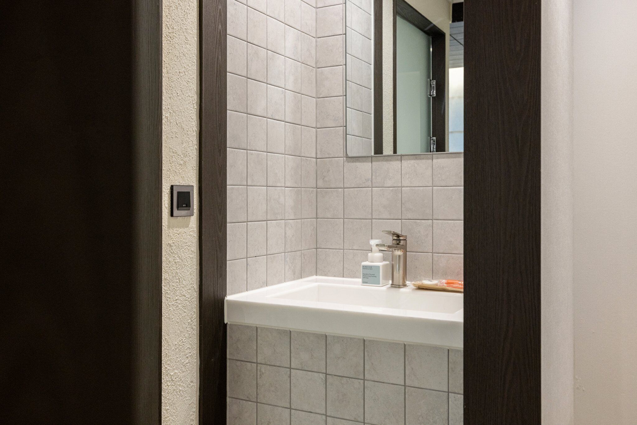 Une salle de bain avec un lavabo blanc, un miroir et un porte-serviettes.