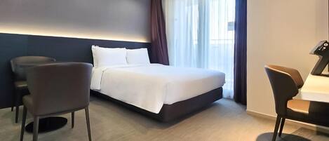 Una habitación de hotel moderna con una cama grande, dos sillas, un escritorio y una ventana con cortinas.