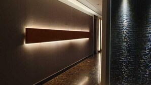 Un couloir doté d’un luminaire moderne et d’un mur à texture.