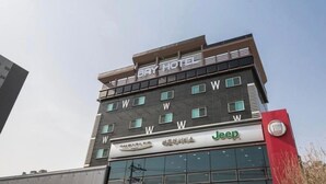 Un immeuble à plusieurs étages, avec une enseigne « HÔTEL » au sommet.