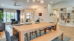 A modern living room with a wooden dining table, comfortable seating, a bookshelf, and a ceiling fan. - Close to Hiking! Snowbird Haven w/ Pool in Phoenix (Phoenix)