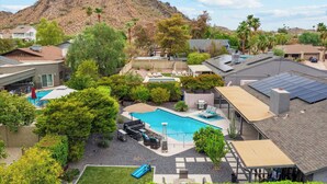 A residential area with a swimming pool, solar panels, and a mountain in the background. - Close to Hiking! Snowbird Haven w/ Pool in Phoenix (Phoenix)