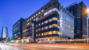 A modern hotel with a curved facade, multiple floors, and a prominent McDonald's sign. - UrCove by Hyatt Beijing Zhongguancun Peking University (Beijing)