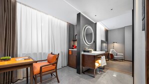 A modern hotel room with a dining area, a large mirror, a desk, and a chair. - UrCove by Hyatt Beijing Zhongguancun Peking University (Beijing)
