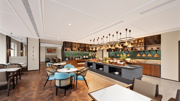 A modern restaurant with a central bar, round tables, and a variety of seating options. - UrCove by Hyatt Beijing Zhongguancun Peking University (Beijing)