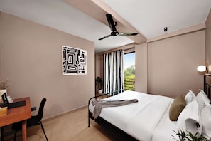 Un dormitorio moderno con una cama, un escritorio y un ventilador de techo.