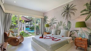 Une chambre à coucher avec un lit, une table de chevet en bois, une commode et une vue sur une piscine et un jardin.