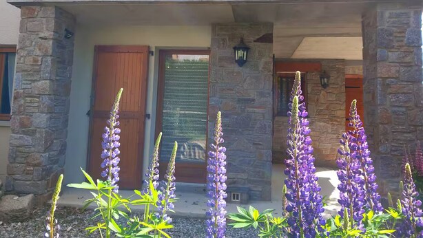 Un edificio in pietra con un balcone di legno e una porta.