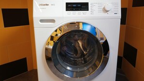 A front-loading white Miele washing machine with a digital display and control panel. - Apartment Luam - Alpstay (Naturno)