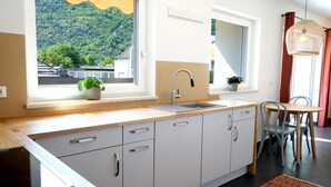 Eine moderne Küche mit großem Fenster, einer Spüle und einem Essbereich mit Stühlen.