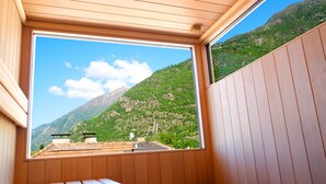 Ein Zimmer mit Holzboden und einem großen Fenster mit Blick auf eine Berglandschaft.
