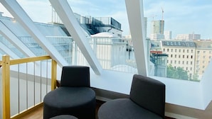 En modern inredning med högt tak och stora fönster med utsikt över stadsbilden.