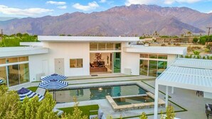 A modern house with a swimming pool, a covered patio, and a mountain backdrop. - Miracle Retreat (Palm Springs)