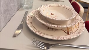 A neatly set dining table with plates, glasses, and cutlery. - VEFA HISTORICAL SUITES HOTEL (İstanbul)