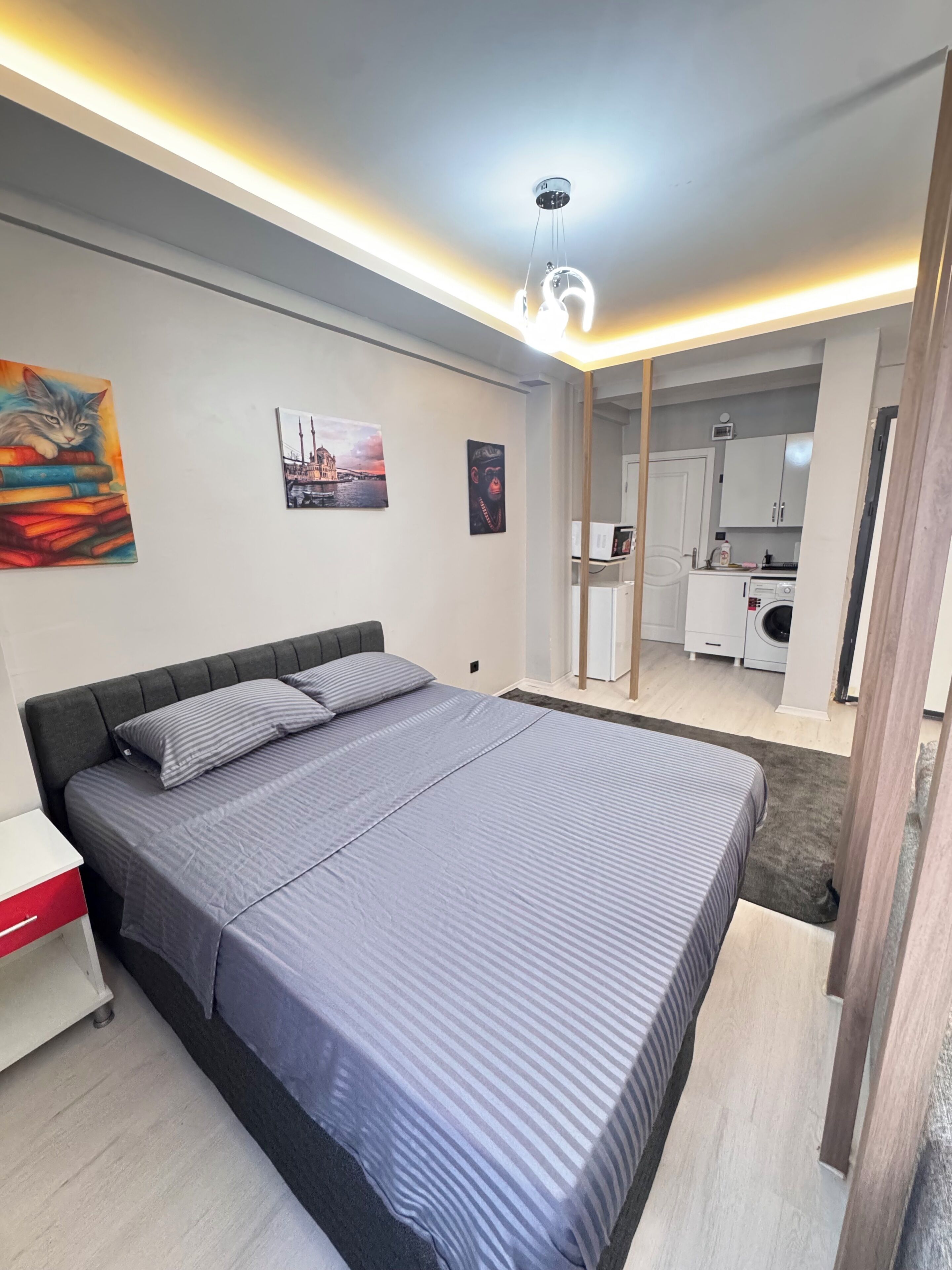 Un dormitorio moderno con una cama, mesitas de noche y un cuadro en la pared.