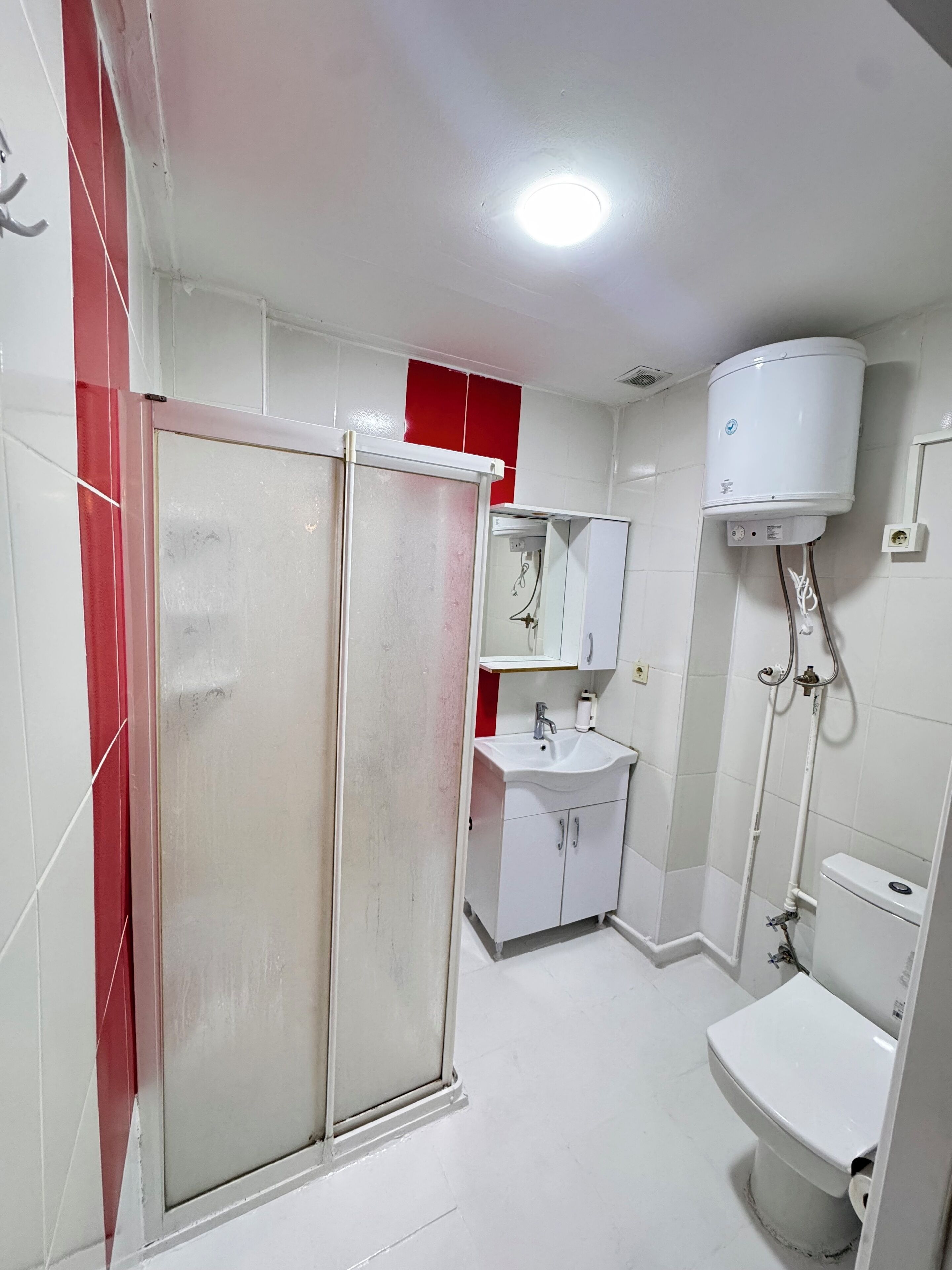 Un baño con ducha, inodoro y lavabo.