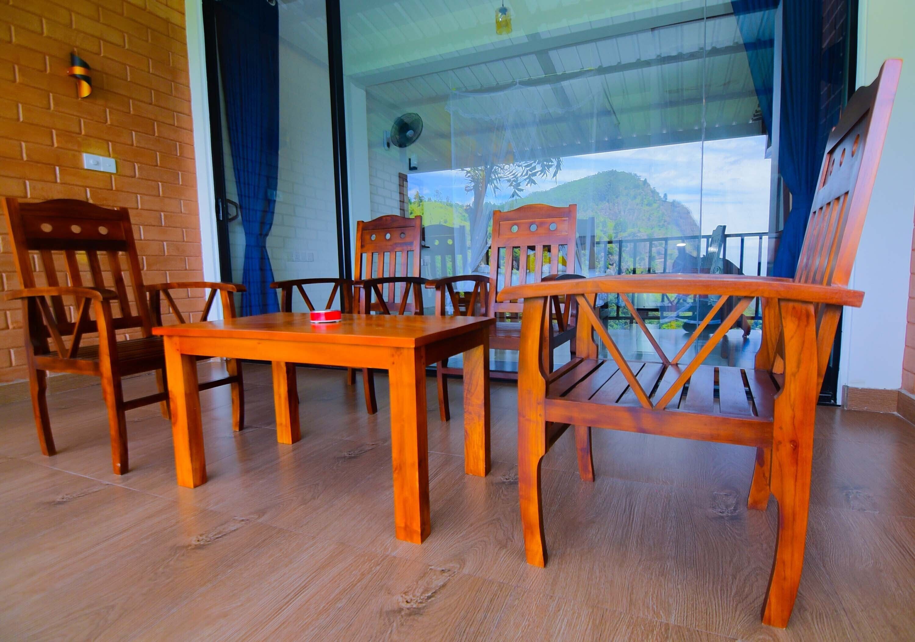 A wooden dining table with chairs, a glass door leading outside, and a view of a mountain.