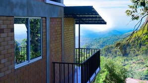A building with a balcony overlooking a mountainous landscape.