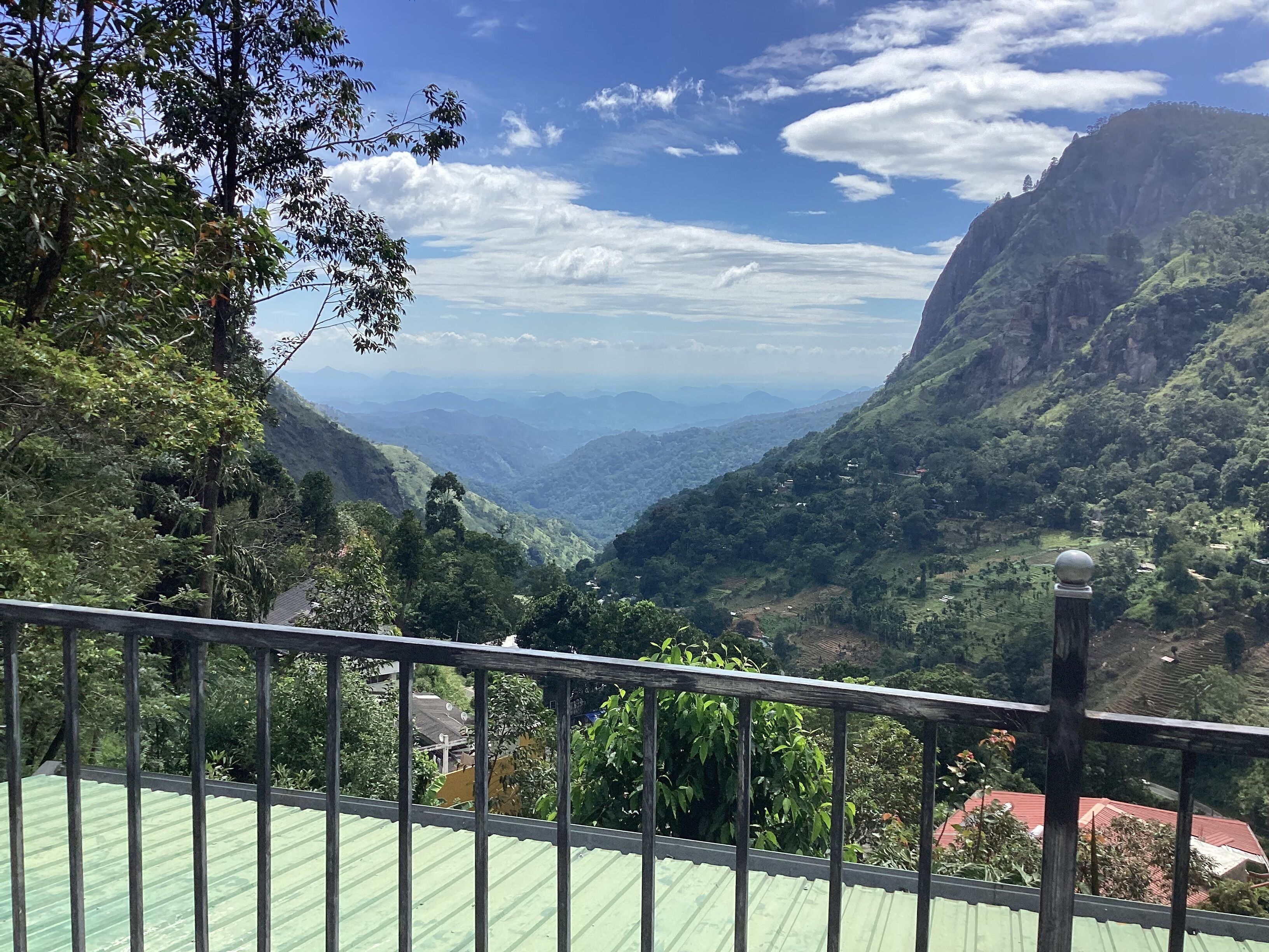 A mountainous landscape with a view of a valley and distant mountains.