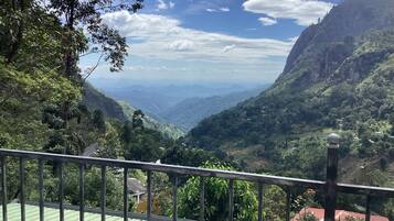 A mountainous landscape with a view of a valley and distant mountains.