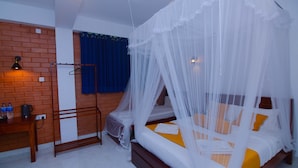 A bedroom with a bed under a canopy, a desk with a chair, and a brick wall.