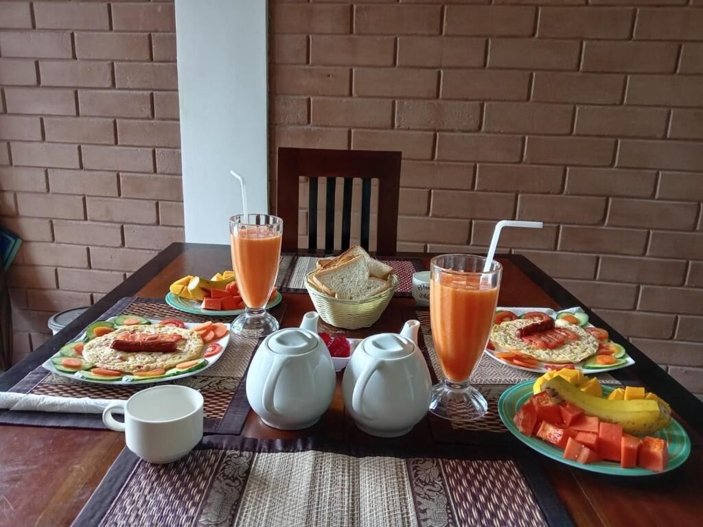 A breakfast table with various dishes, including toast, fruit, and a glass of orange juice.