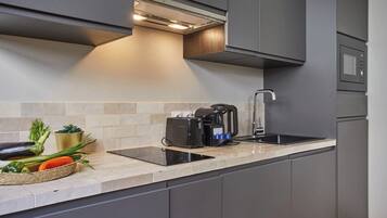 Une cuisine moderne équipée d’une cuisinière intégrée, d’une machine à café et d’un évier.