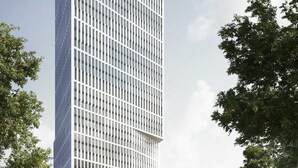 Un moderno edificio de gran altura con fachada de entramado, una entrada destacada con puertas de vidrio y un letrero que dice "messe frankfurt".