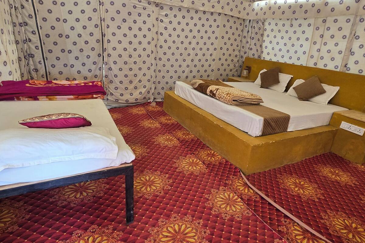 A room with a bed, a bedside table, and a chair.