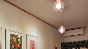 A bedroom with a bed, a dresser, a wall-mounted air conditioner, and framed pictures on the wall. - Strawberry_Charming studio with AC in vibrant Ewha Univ. neighborhood (Seodaemun-gu,)