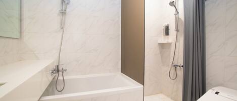 Ein Badezimmer mit Badewanne, Dusche, Toilette und Spiegel.