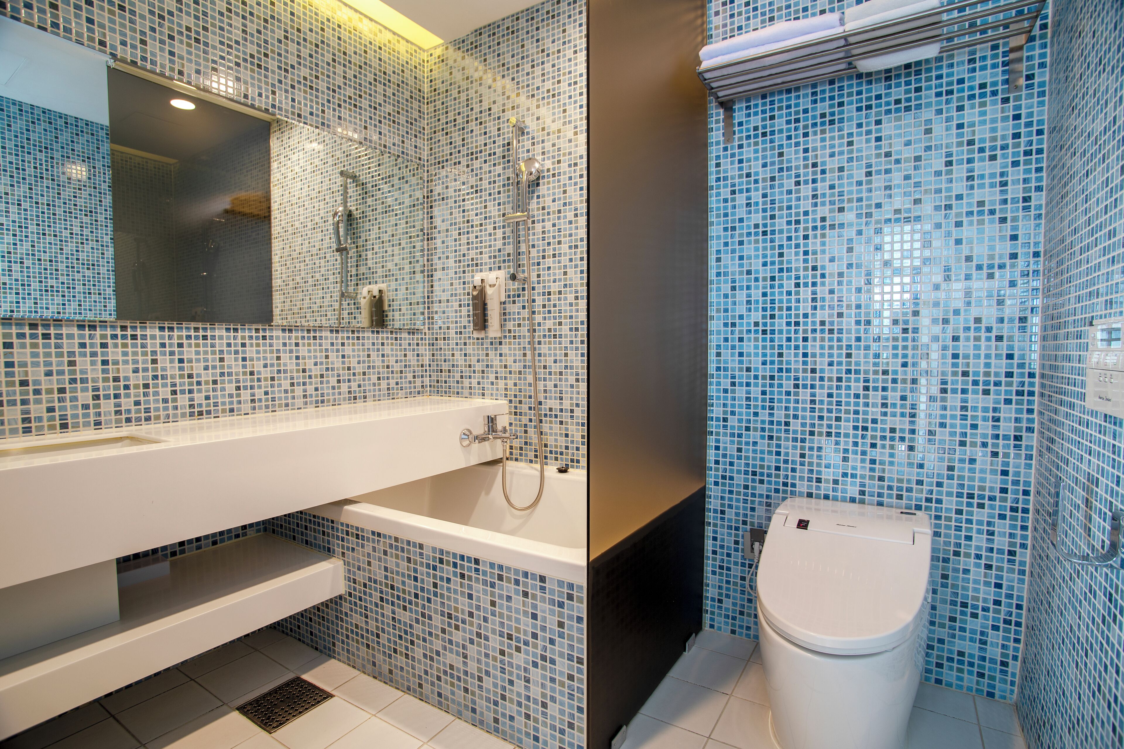 A bathroom with a white bathtub, a mirror, and a toilet.