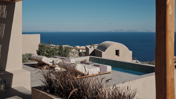 Zona exterior moderna amb piscina, gandules i vista al mar.