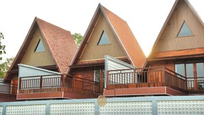 Una hilera de edificios con techos triangulares, balcones y ventanas amplias.