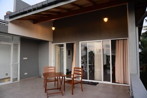 An outdoor patio with a table and chairs, sliding glass doors, and a wooden ceiling. - Dady`s Place `63` German standard with Singalese charm - beach in 2 min (Hikkaduwa)