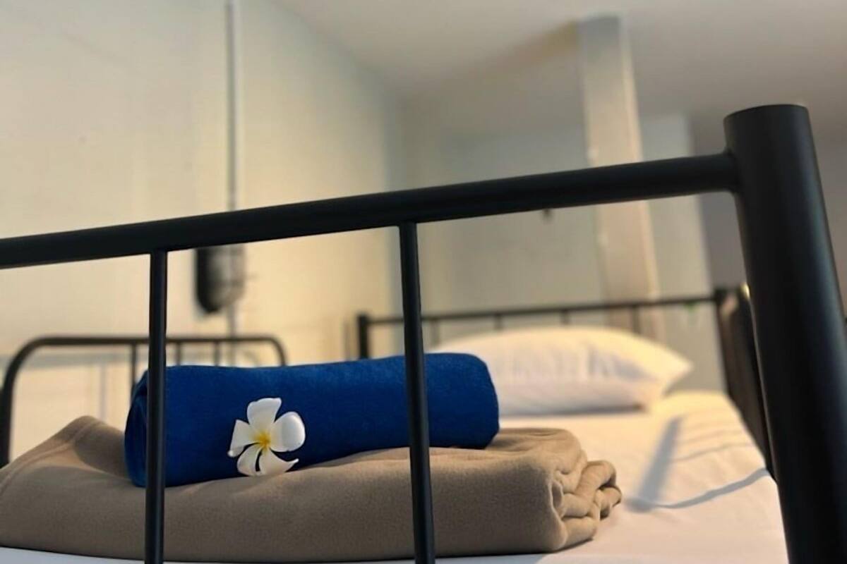 A bunk bed with a blue pillow and a white flower on the lower bunk.