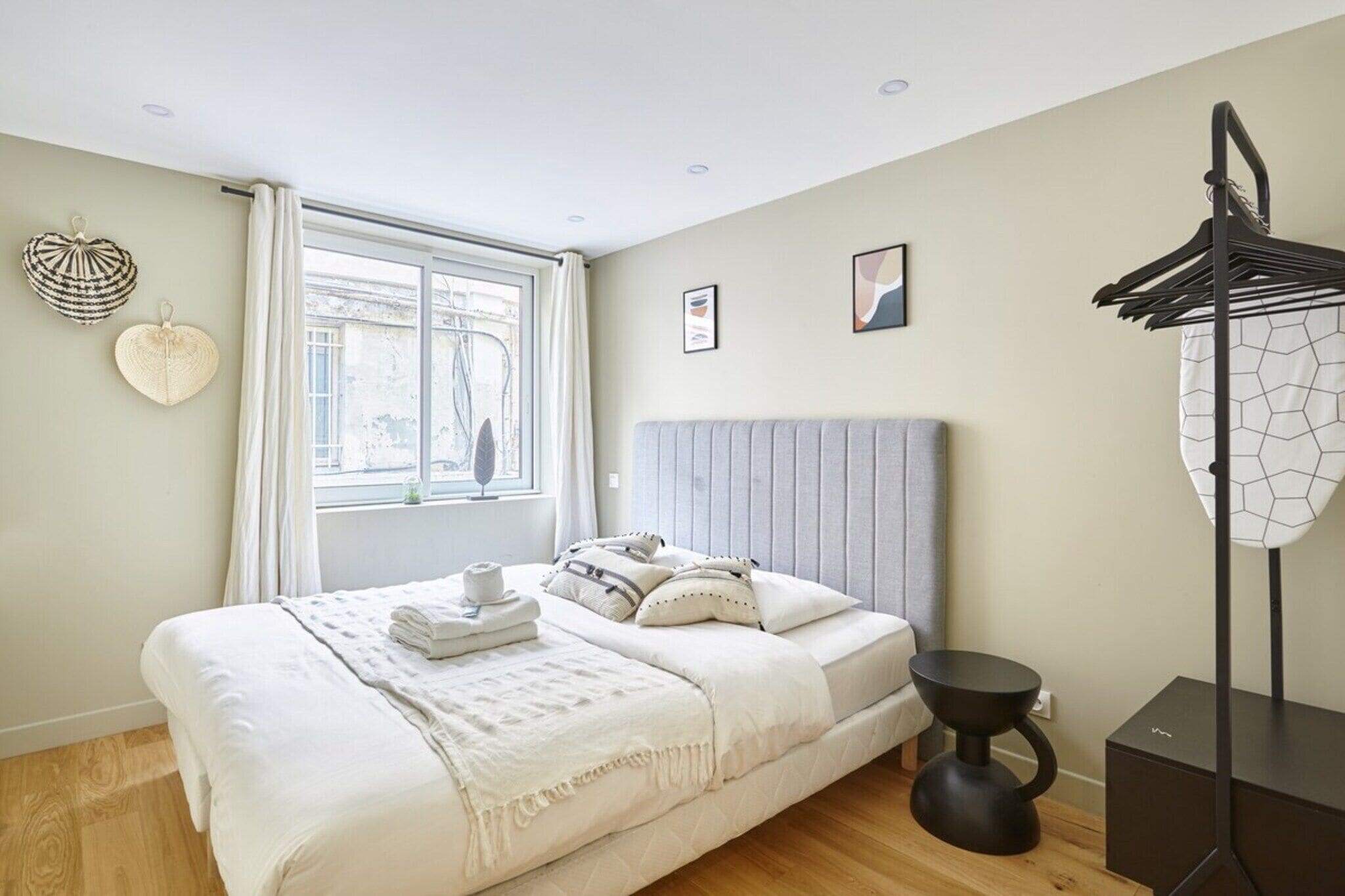 Escritorio, tabla de planchar con plancha y ropa de cama 