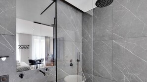 A modern bathroom with a large mirror, a sink, and a shower. - Superb Suite with AC Beaubourg Le Marais (Paris)
