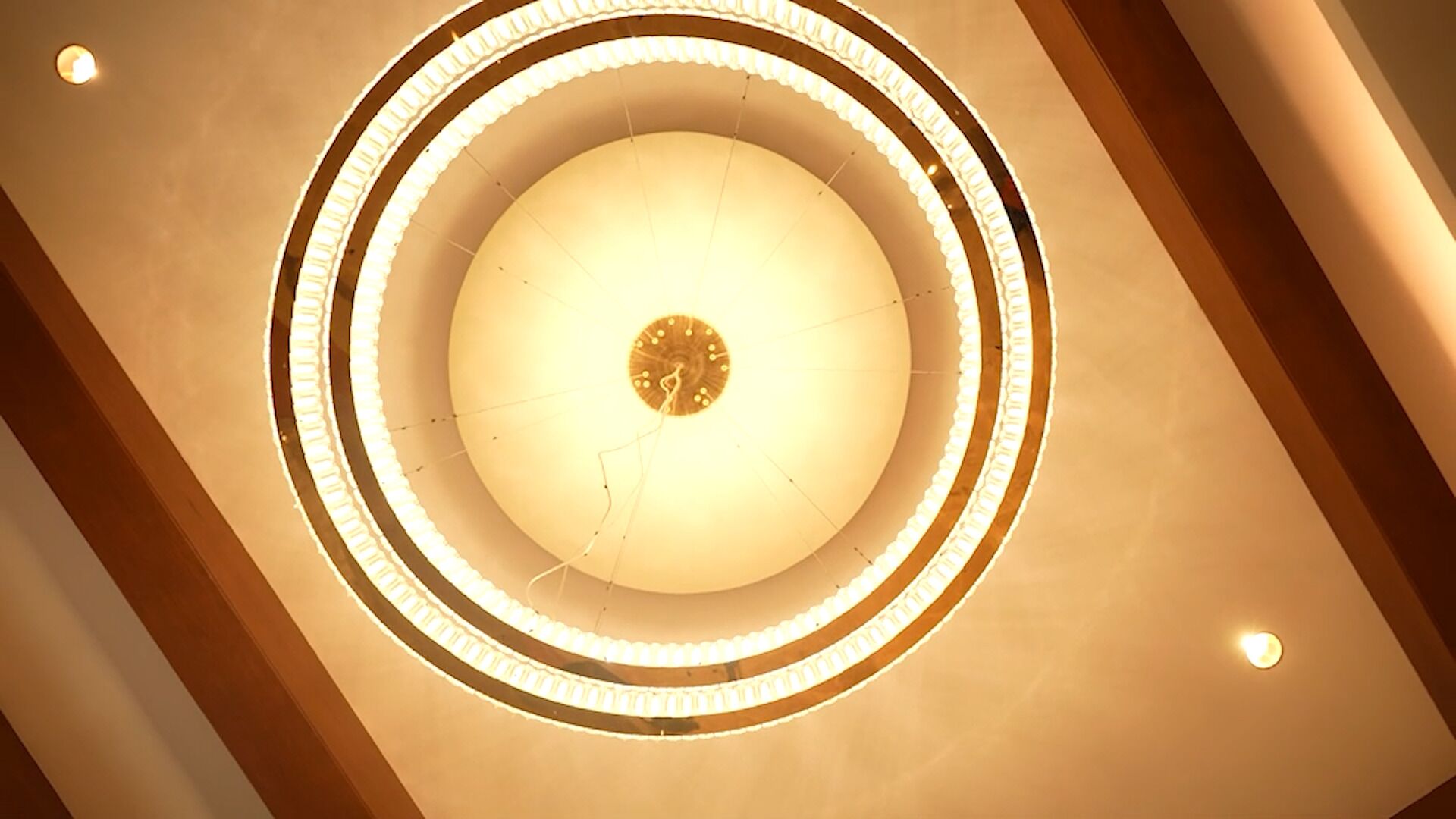 Un motif circulaire au plafond, avec des luminaires disposés en cercles concentriques.