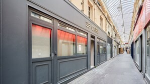 Un couloir bordé de boutiques, dont un bâtiment portant l’inscription « 33 CAFE ».