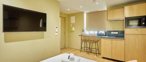 Escritorio, tabla de planchar con plancha, ropa de cama