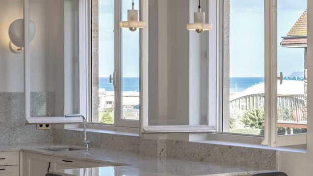 A kitchen with a large window, a sink, and two chairs. - Luxury sea view 3BR-2BA with services in Deauville (Deauville)