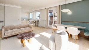 A modern living room with a sofa, coffee table, and dining area with chairs and a table. - Luxury sea view 3BR-2BA with services in Deauville (Deauville)
