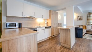 Une cuisine moderne avec des meubles en bois, un four à micro-ondes et une machine à café.
