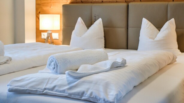 Ein Hotelzimmer mit einem Bett, Kissen und einer Lampe.