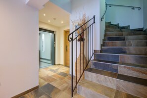 Eine Treppe mit Stein trittstufen und einem Metallgeländer, die zu einer Tür mit Glasfenster führt.