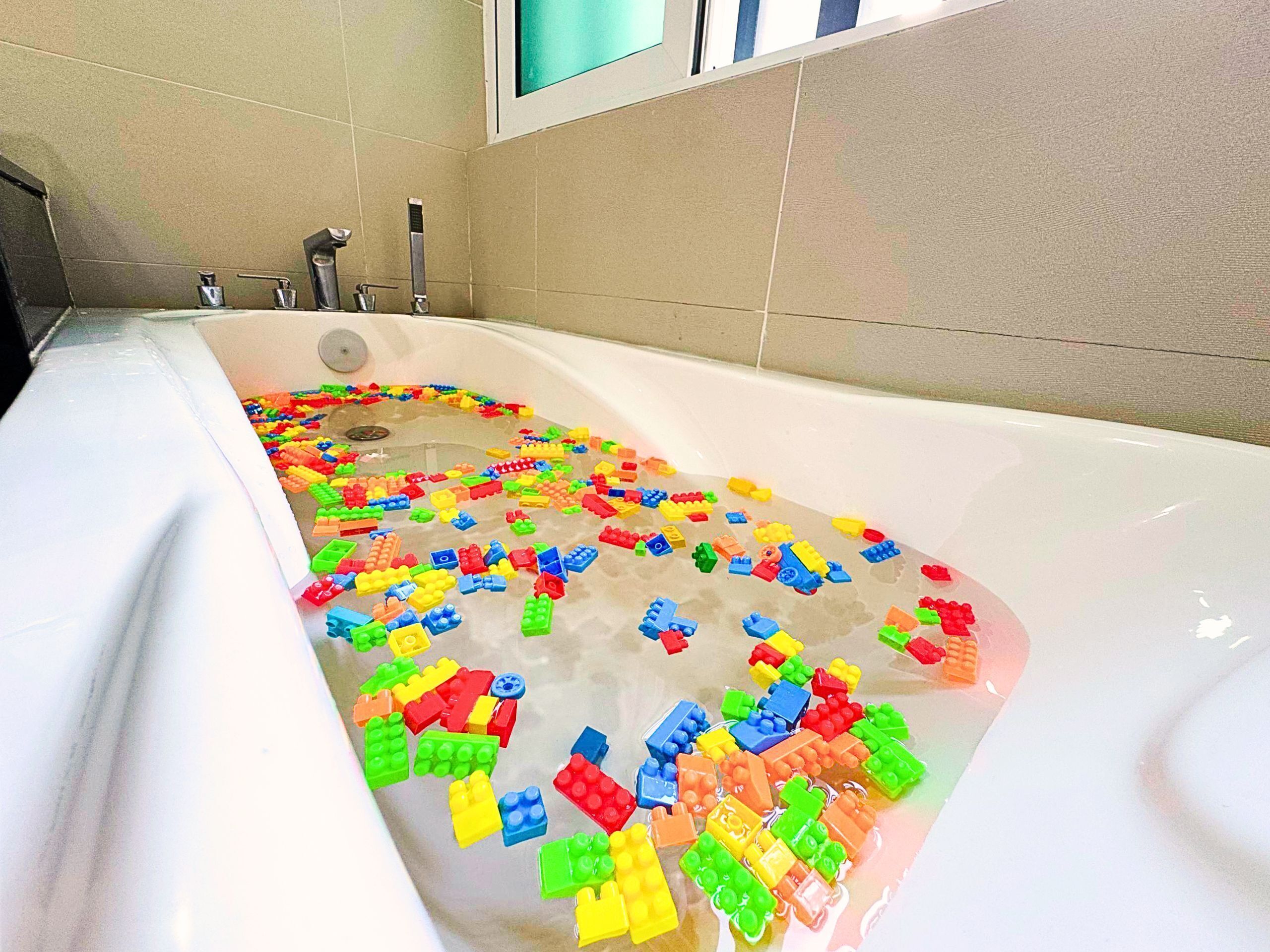 A bathtub filled with colorful building blocks.