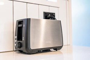 A stainless steel toaster with a digital display and control buttons on a countertop. - 1BR with Courtyard + Parking | Near CBD (Christchurch)