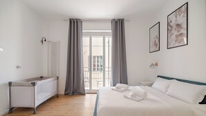 Une chambre à coucher avec un lit, un radiateur, une fenêtre avec des rideaux et un balcon.